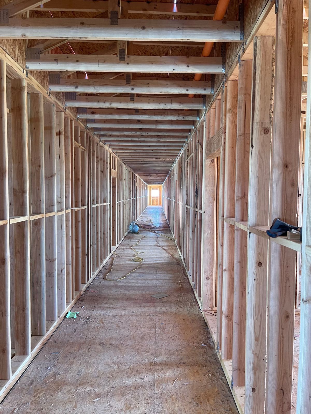 Acacia Heights Phase II interior: long corridor of framed unit walls under the floor framing