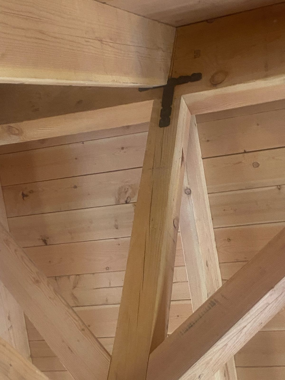 Grand Canyon Cabin detail: blackened steel strap joining the timber post, brace and ridge beam