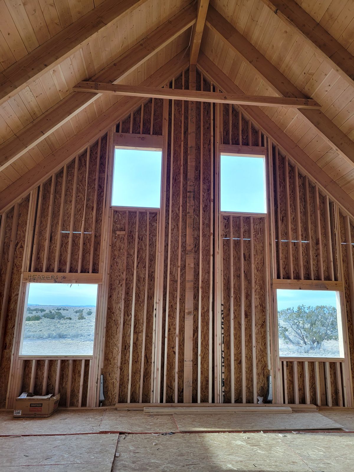 Grand Canyon Cabin interior: framed gable wall with window openings under a tongue-and-groove vaulted ceiling