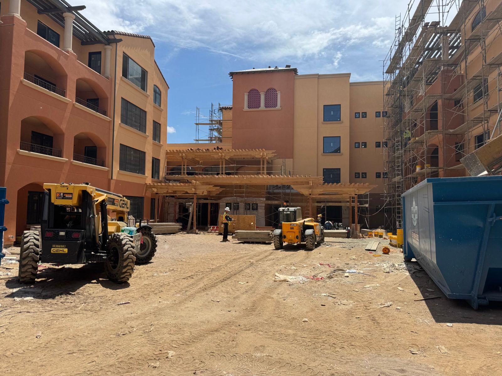 Maravilla Scottsdale courtyard during construction, with scaffolding and telehandlers