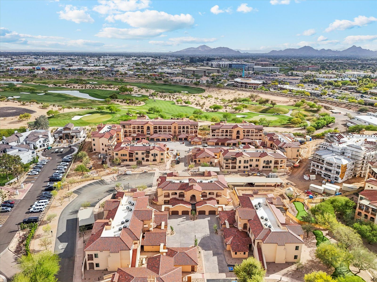 Mediterranean-style multi-family condominium community under construction alongside a golf course