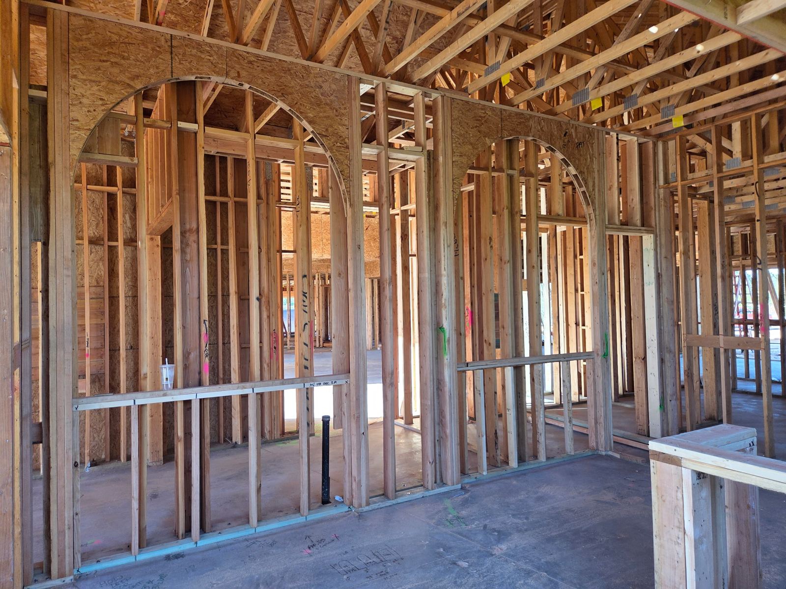 Mescal Residence interior: arched wall openings framed beneath the roof trusses