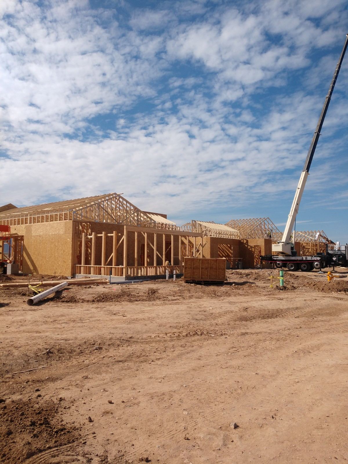 Prasada Country Club Main Building: roof trusses set on sheathed walls, with a crane on site